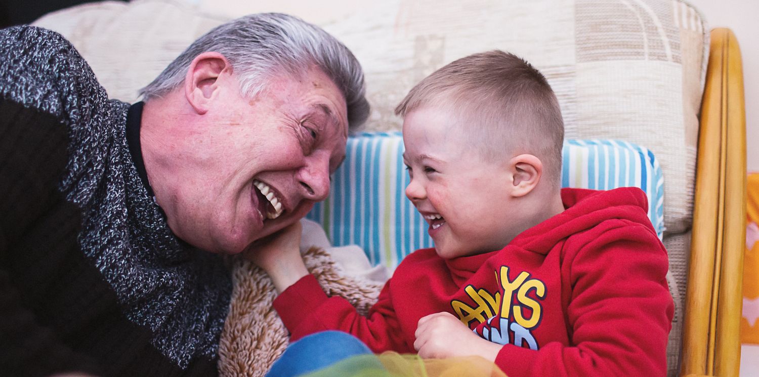 A man and a child smiling at each other